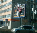 На ул. Октябрьской над дорогой развевается оторвавшийся кусок рекламной вывески