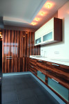 Мебель на кухне выстроена по двум стенам. Фасады – под дерево, что перекликается с деревянными элементами в гостиной, Фото: 1
