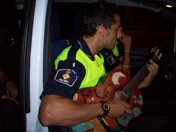 Полицейский Пальмы-де-Мальорка играет на гитаре, одолженной у уличных музыкантов.))